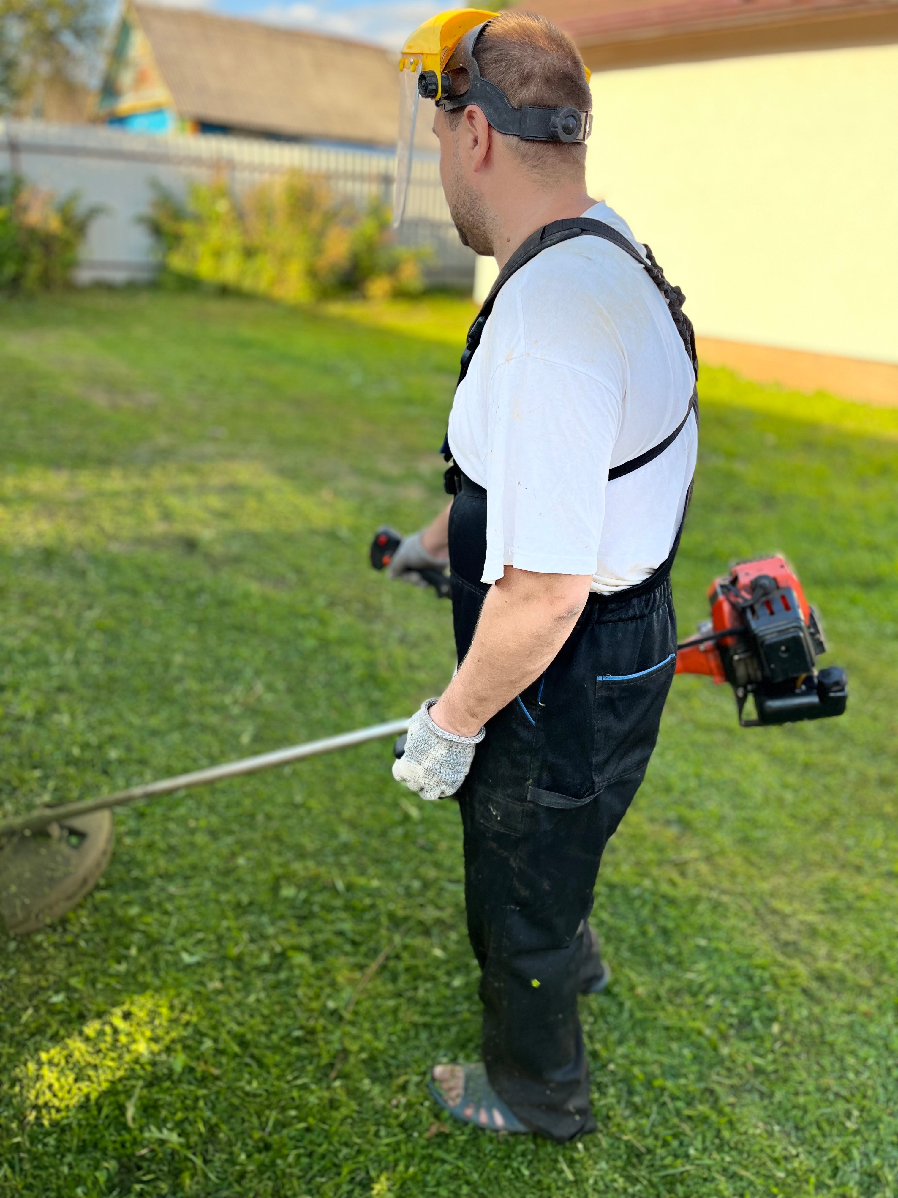A,Worker,Mows,The,Grass,With,A,Manual,Lawn,Mower